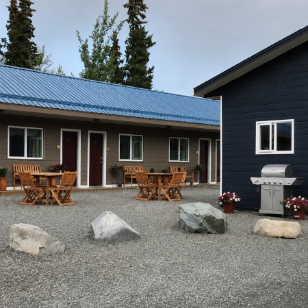 Parkside Inn exterior seating area in Haines Junction, Yukon showing suites with outdoor patio furniture and BBQ grill